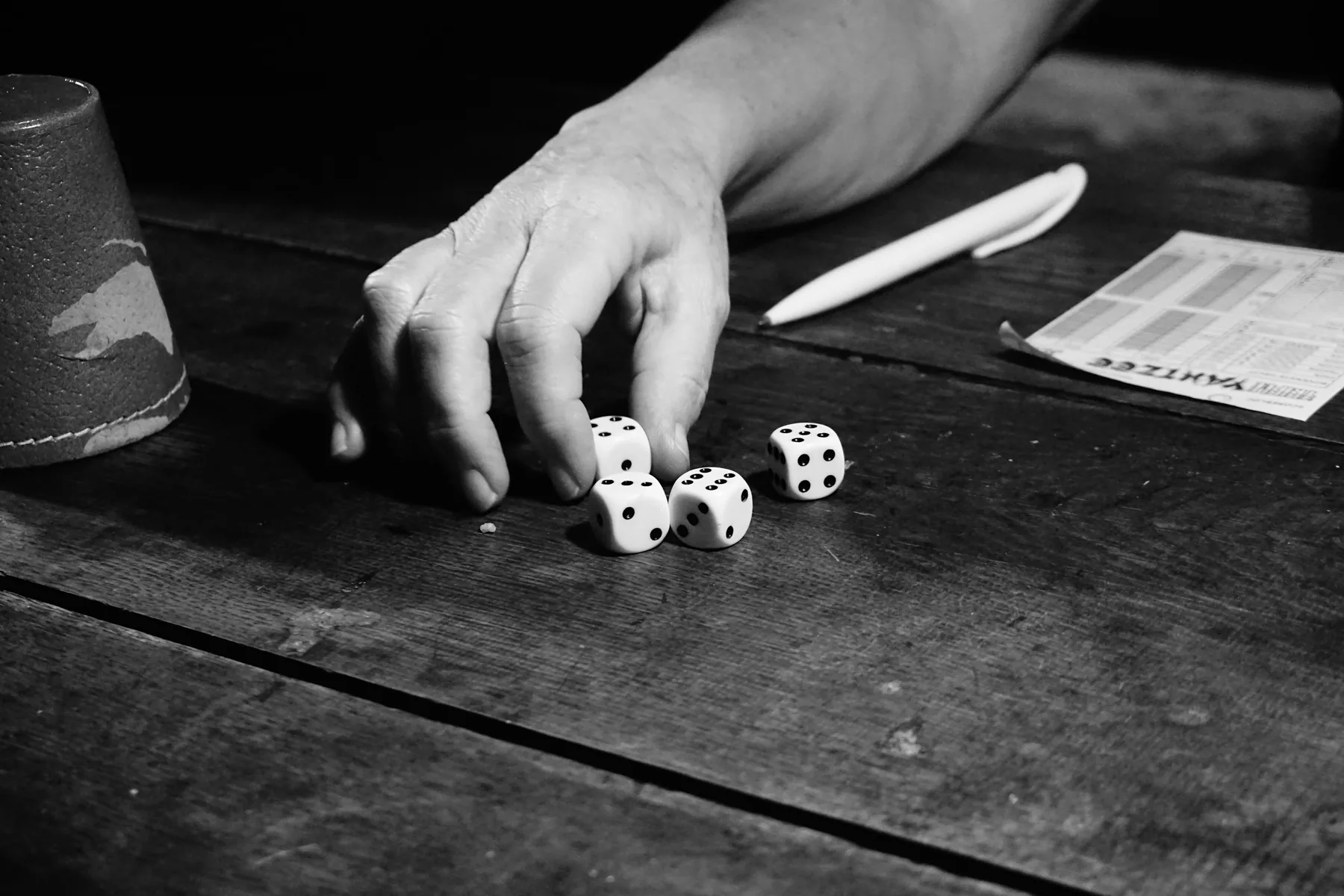 Hands rolling dice on a game table
